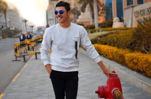 Young man posing by fire hydrant in vibrant cityscape